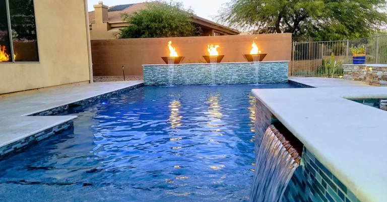 Remodeled pool with fire bowls and evening lighting